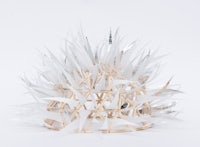 a sculpture made out of paper straws on a white surface